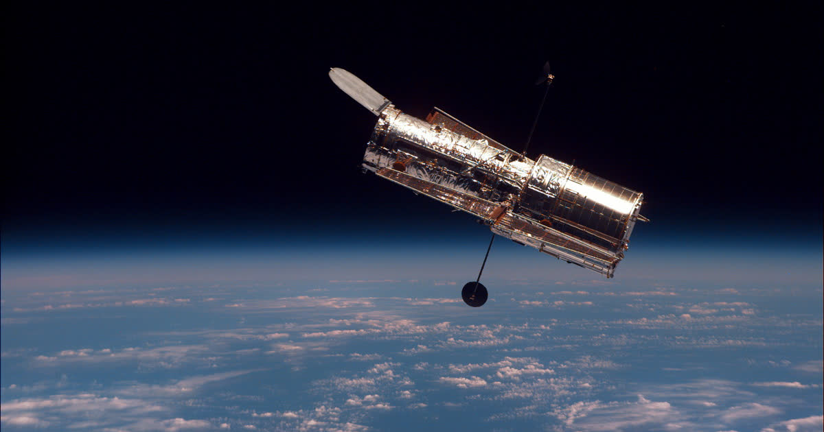 The Hubble Space Telescope in orbit above Earth's blue horizon and white clouds, ahead of a possible reboost